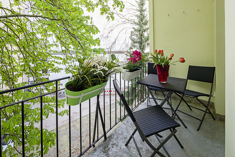 Balkon mit Rattan Gartenmöbeln und Blumenkästen am Geländer
