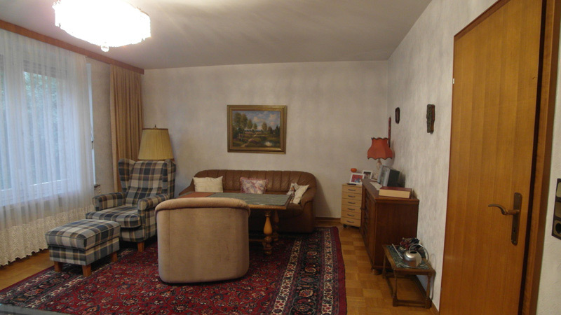 Altmodisches Wohnzimmer mit einem Orientteppich, alten Sesseln und einem Ledersofa