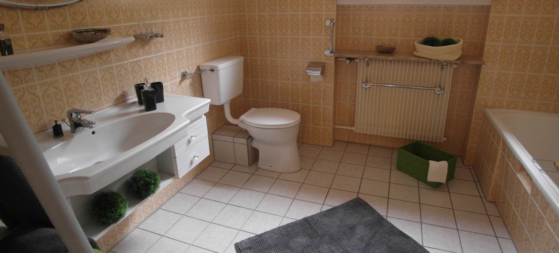 Altmodisches Badezimmer mit beige-braunen, floralen Wandfliesen