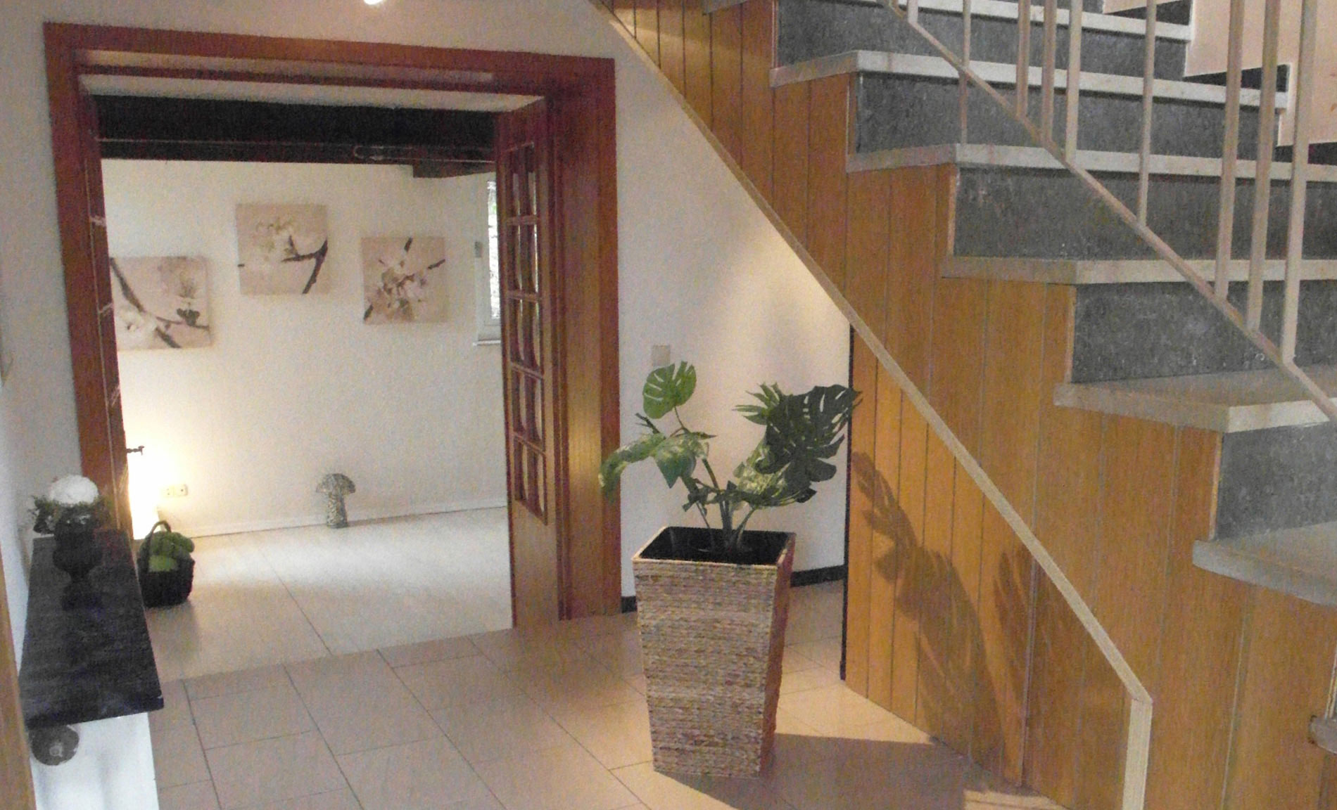 Treppenhaus mit Holz-Doppeltür und einer Treppe mit seitlicher Holzverkleidung