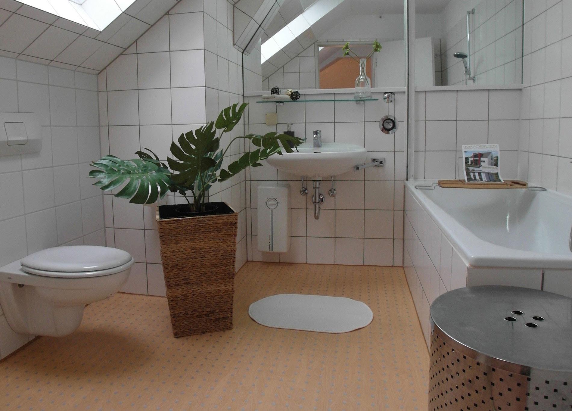 Weißes Badezimmer mit einer Grünpflanze und Teppichboden