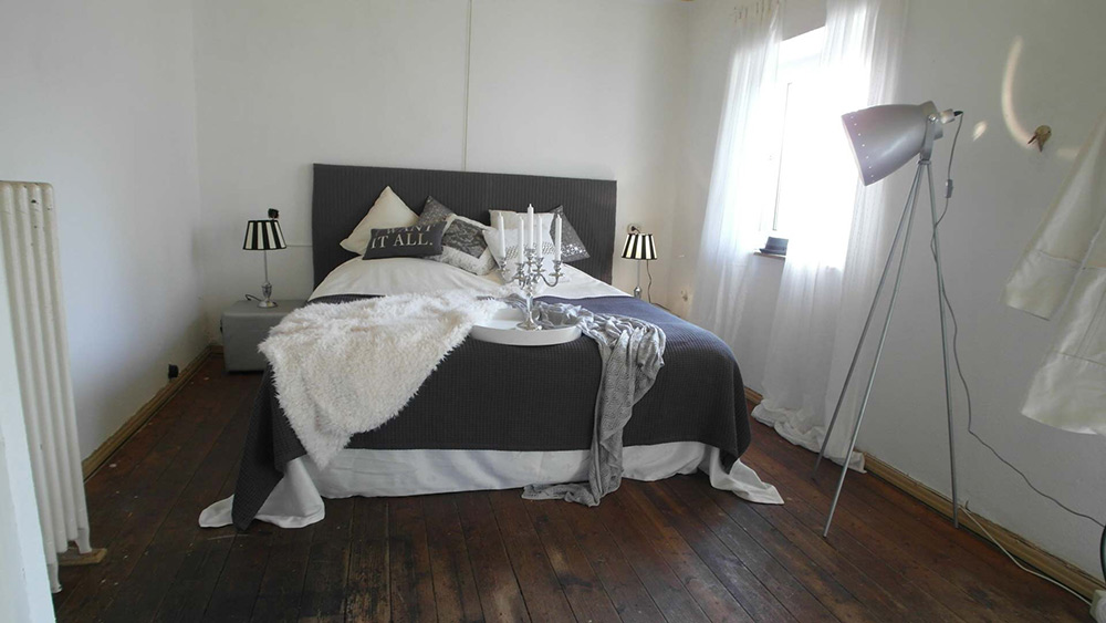 Schlafzimmer mit einem Doppelbett und Echtholzboden